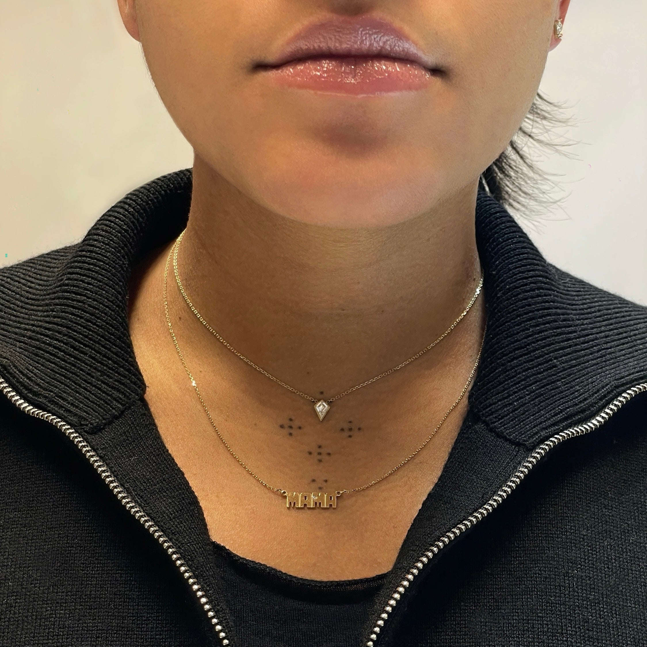 Woman wearing diamond bezel kite necklace with Mama necklace