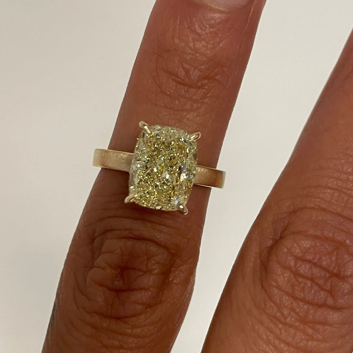 Faint Yellow Cushion Selent Ring on Finger Close Up View