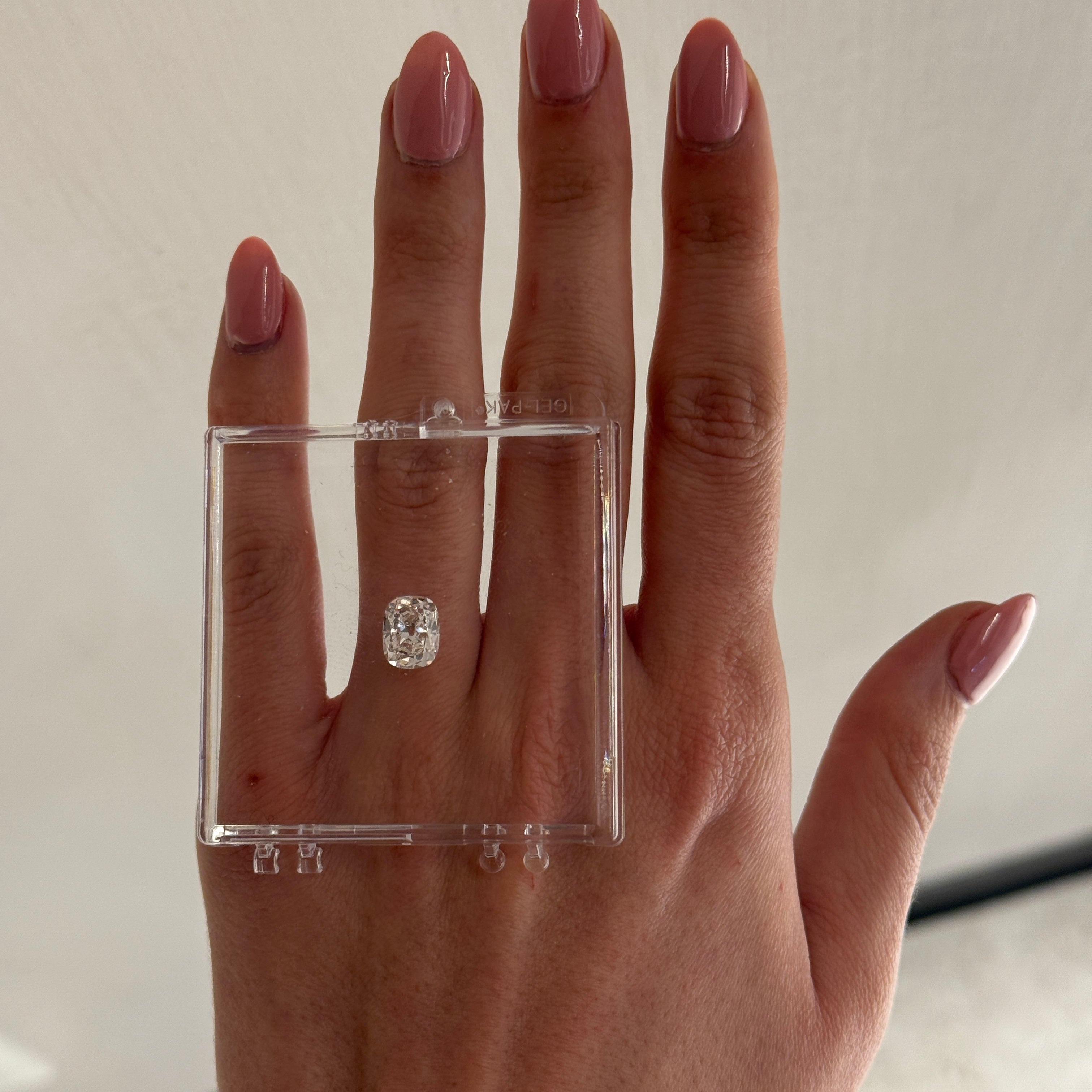 Hand with loose diamond laid over ring finger