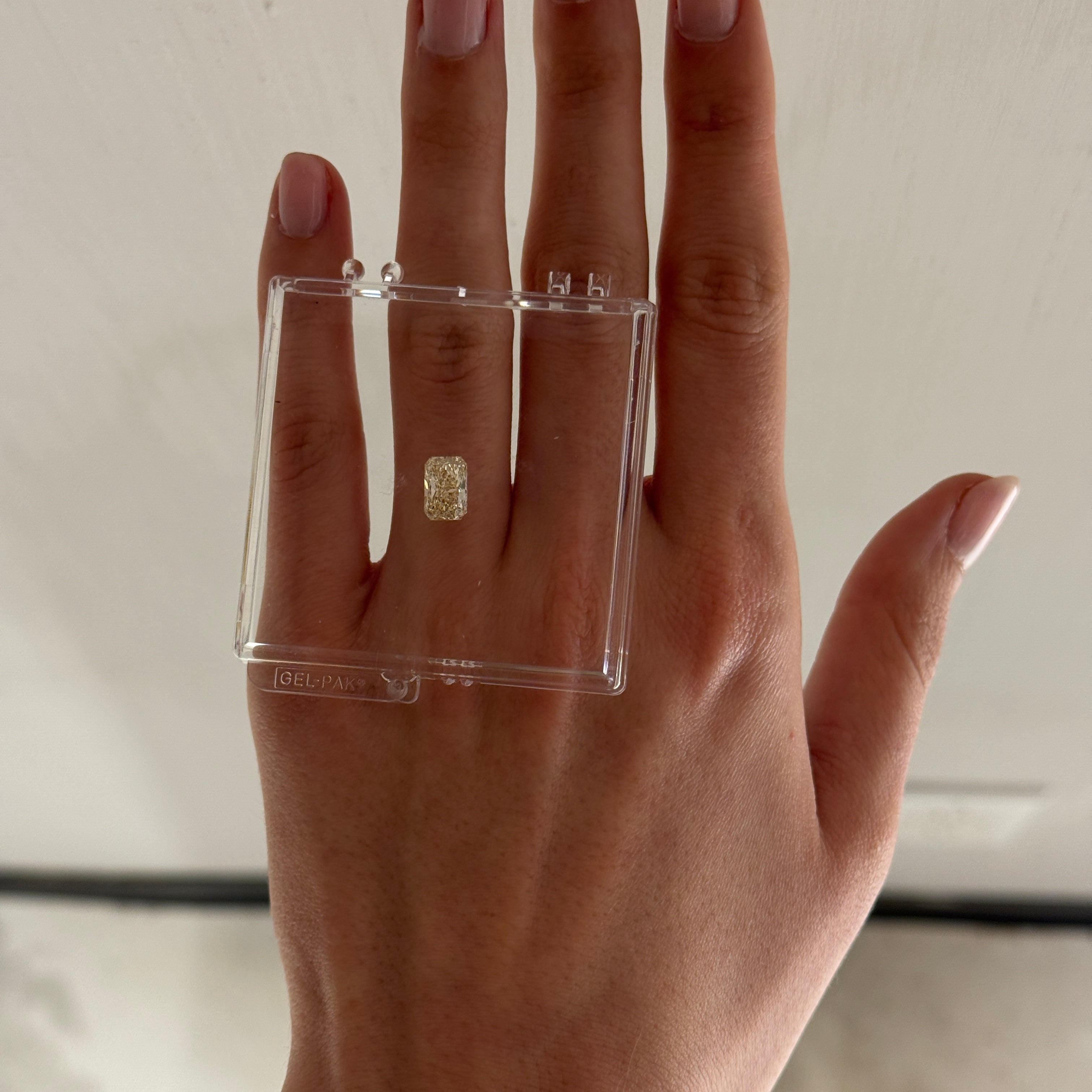 loose UV color radiant cut diamond shown on a hand