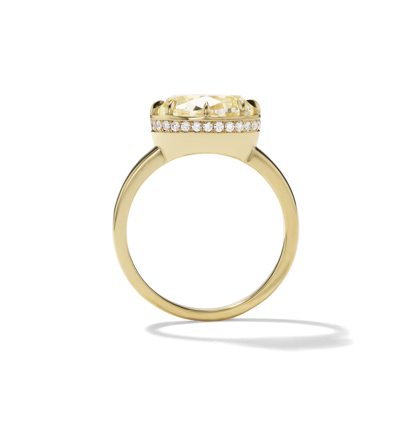An 18KT yellow gold ring with a large oval yellow diamond centerpiece and a hidden halo of smaller diamonds around it.