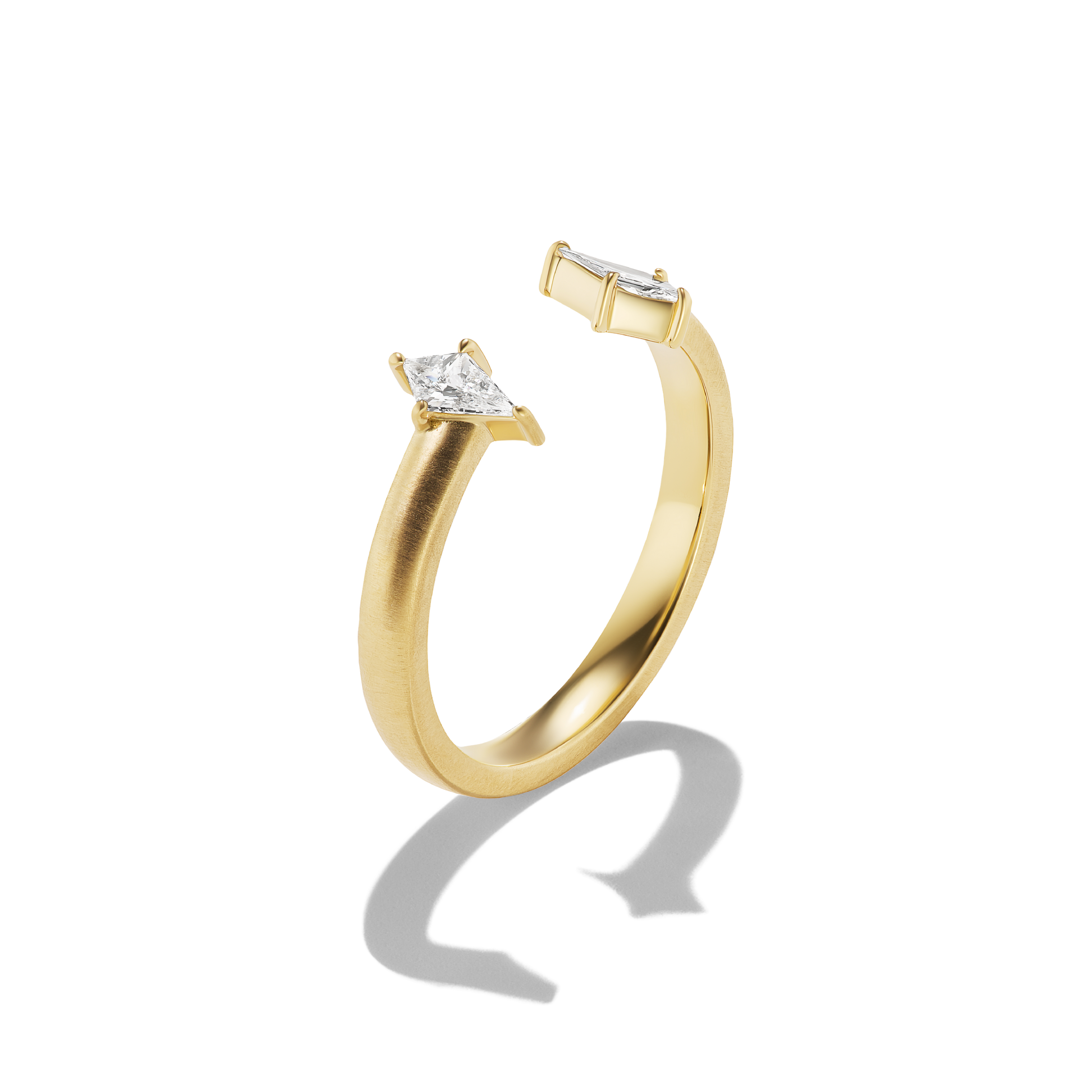 A gold open-shank ring featuring a small kite-cut clear gemstone in a prong setting, photographed on a clean white background with a soft shadow.