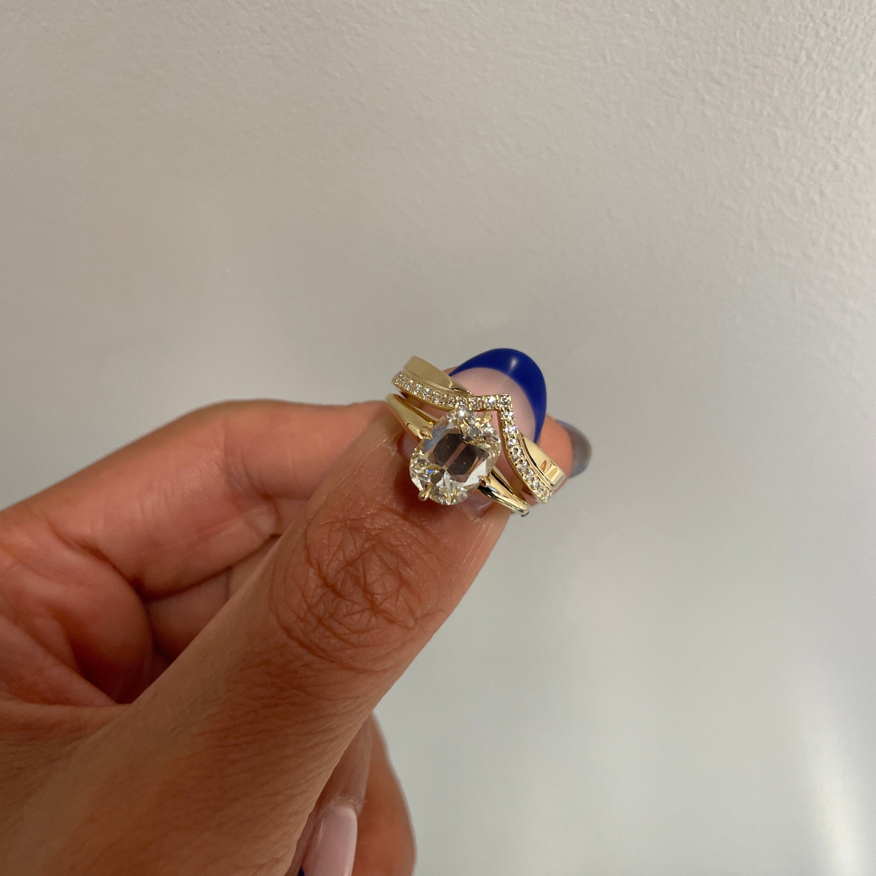 Petite V-shaped Cigar Wedding Band, held with MAE Ring