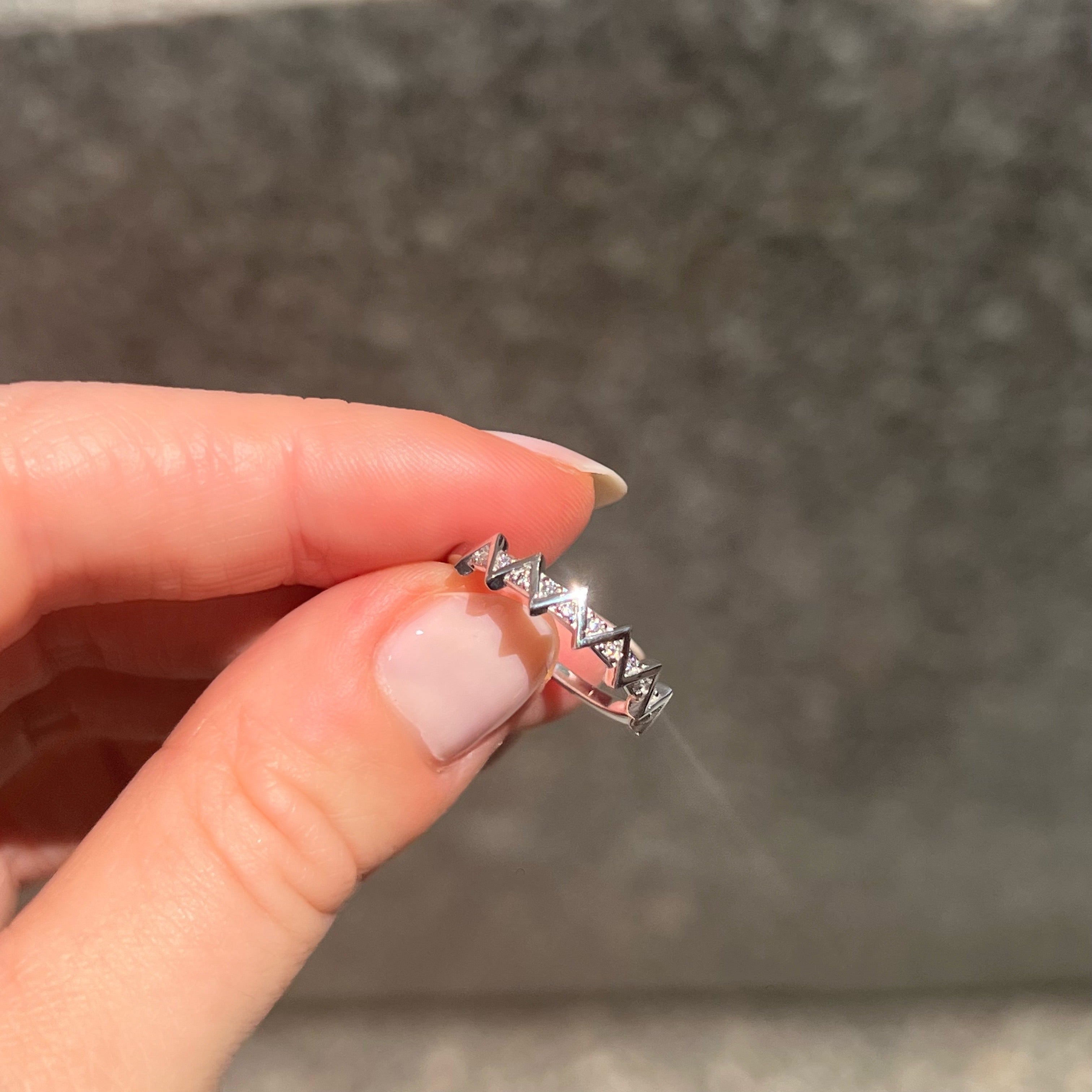 ZIG ZAG 14KT WHITE GOLD DIAMOND RING - held between fingers