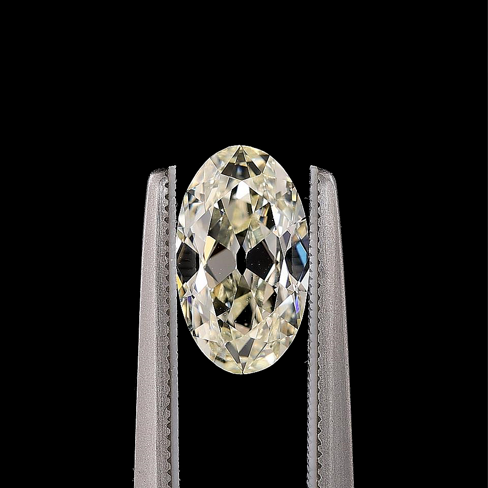 A single elongated oval-cut warm white diamond between tweezers on black background
