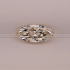 A marquise-cut diamond with brilliant faceting, displayed horizontally against a neutral, light beige background.