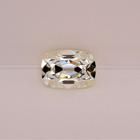 A old mine brilliant diamond with brilliant faceting, displayed on a clean, light pinkish-beige background.