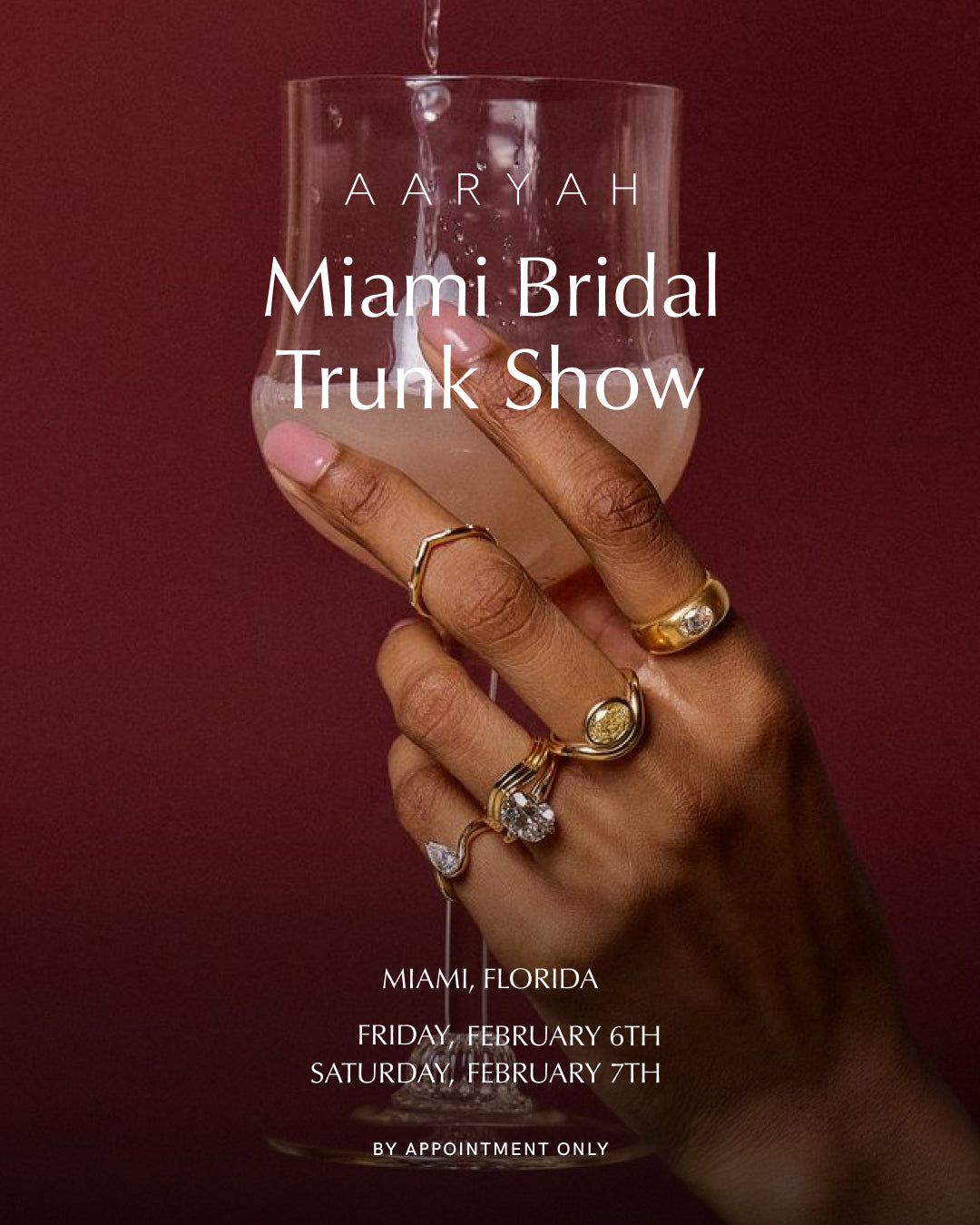 Hand holding a glass with 'Aaryah Miami Bridal Trunk Show' text on a red background