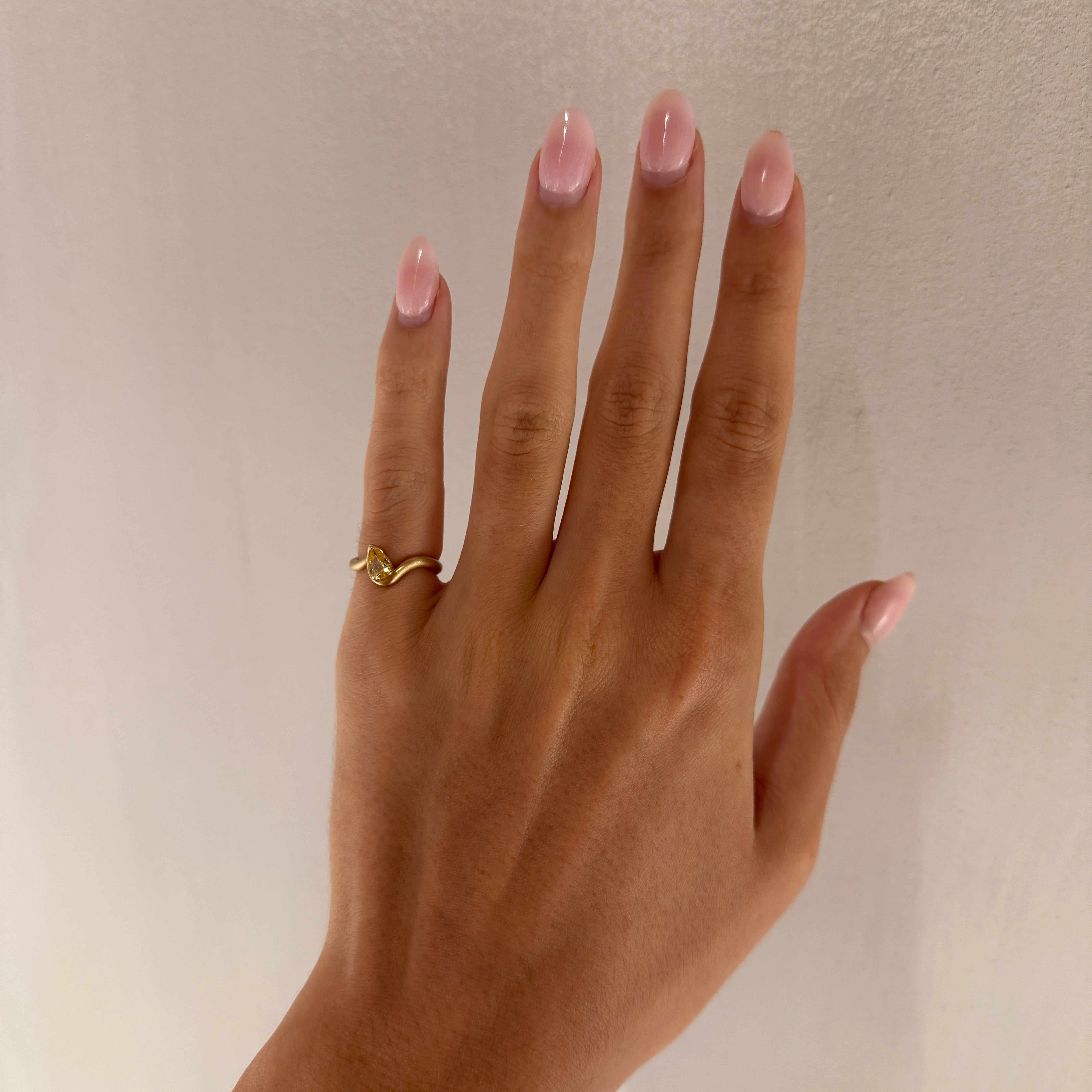 BB Thelma Citrine pinky ring, 14k yellow gold,  on hand in front of a white wall. 