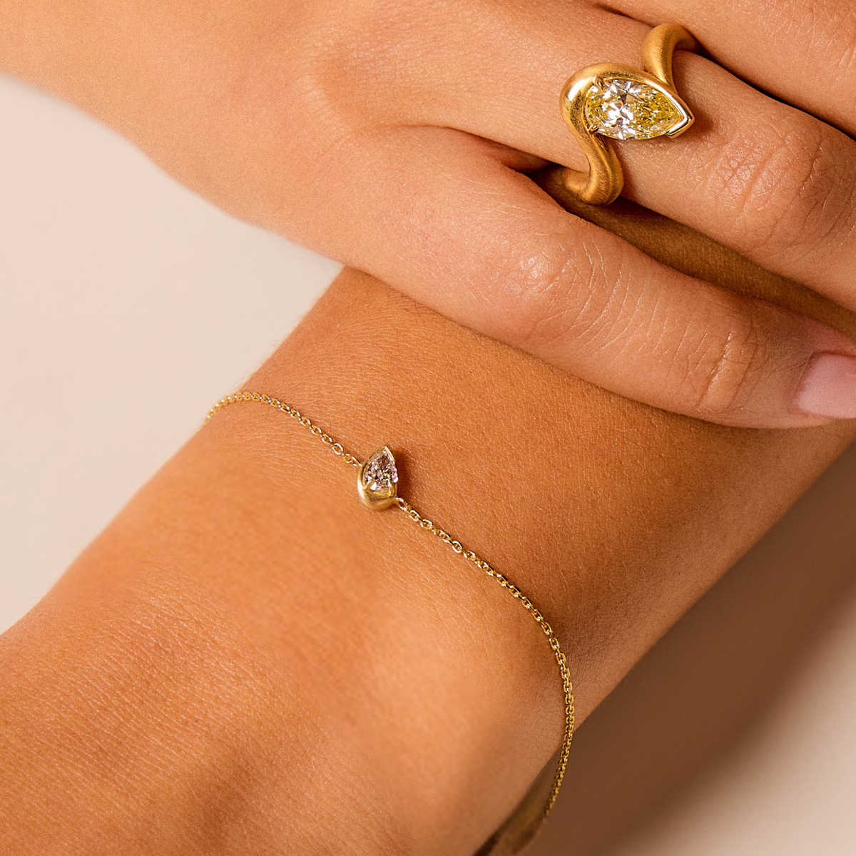 Fine Chain Bracelet with Pear White Diamond Pendant with semi bezel, on wrist. Yellow Diamond Thelma Engagement Ring