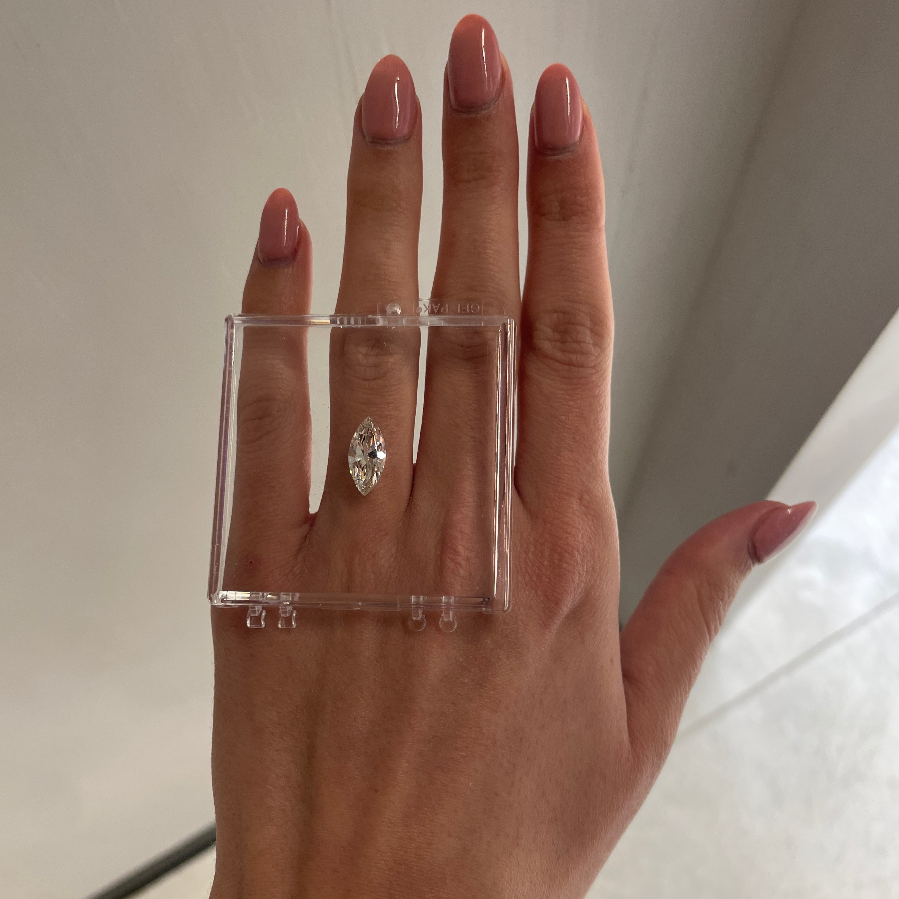 marquise cut diamond in a clear box over hand