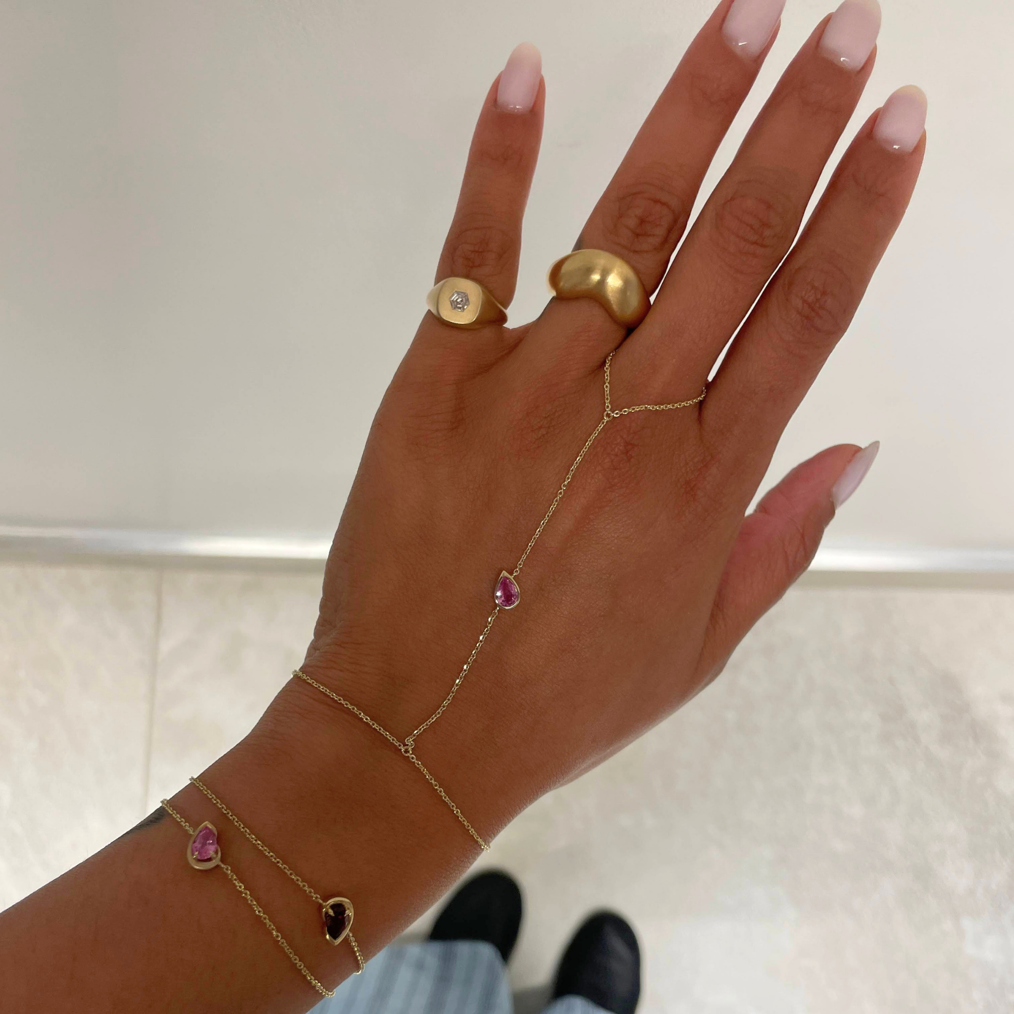 pink sapphire hand chain on woman's hands