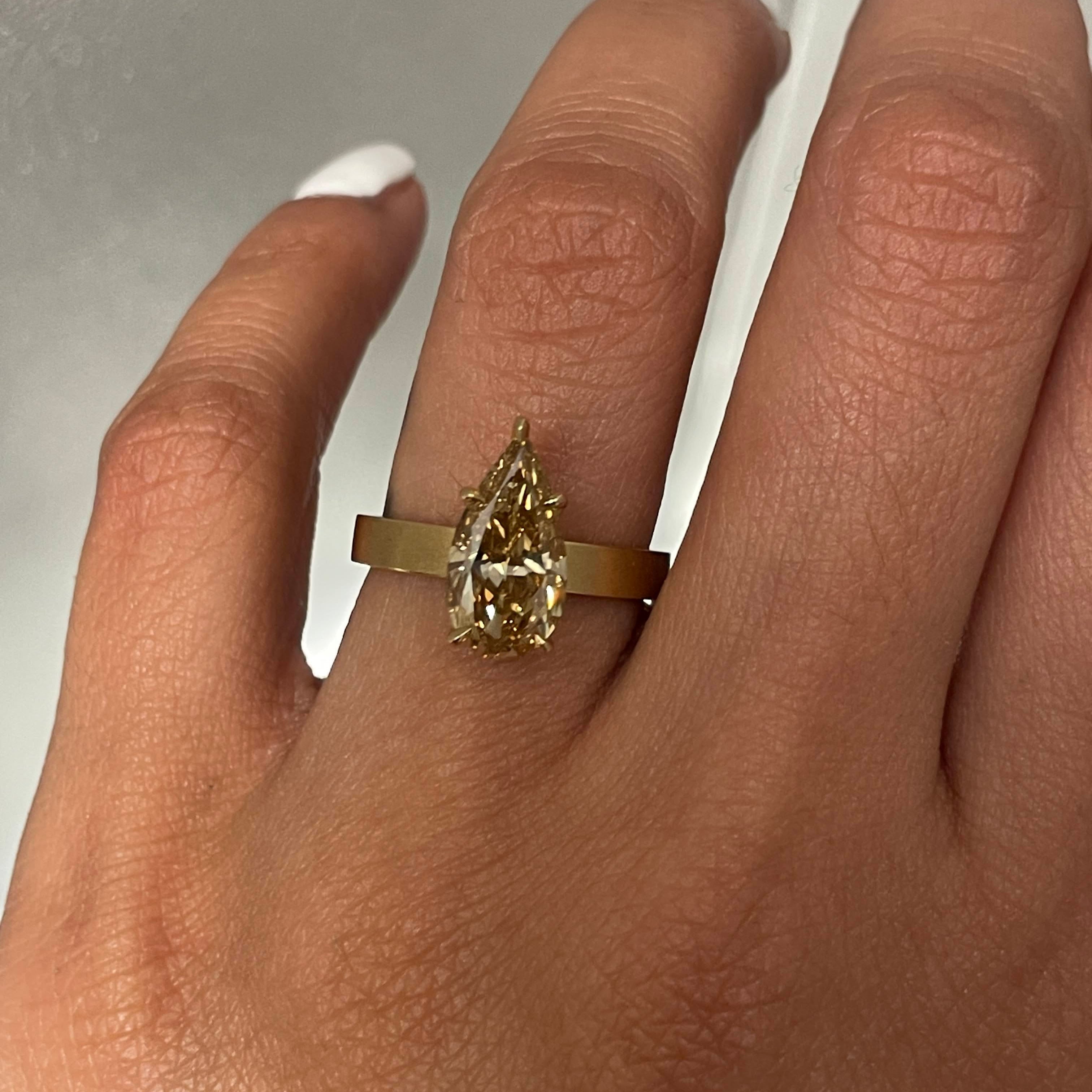 SELENE 2.28 RING with a pear-shaped diamond on a person's finger against a neutral background