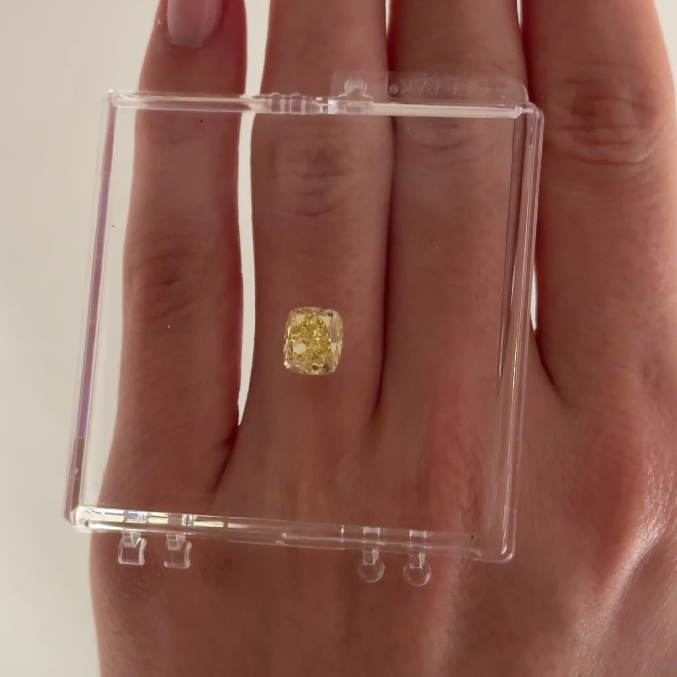 2.74 crt cushion modified brilliant yellow diamond on a hand moving back and forth