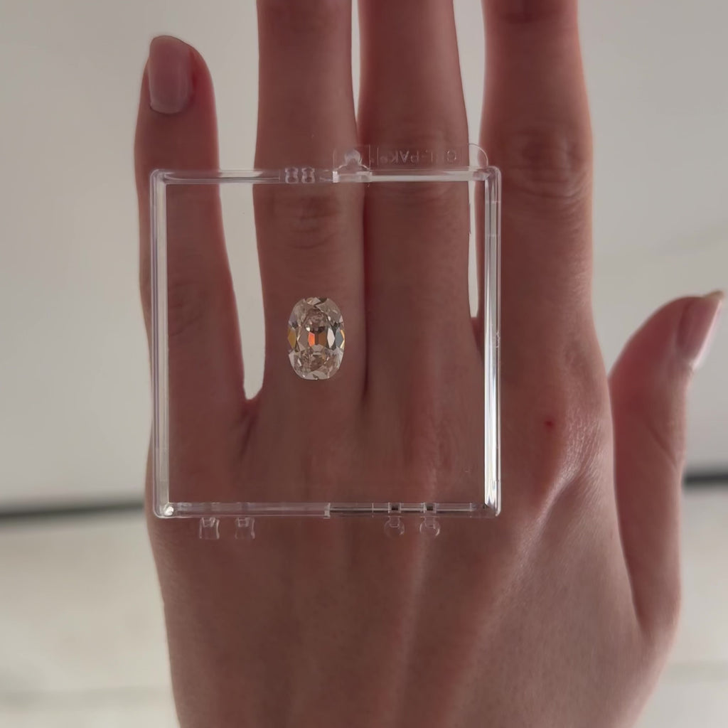 loose cushion brilliant cut diamond on gel box on hand moving back and forth