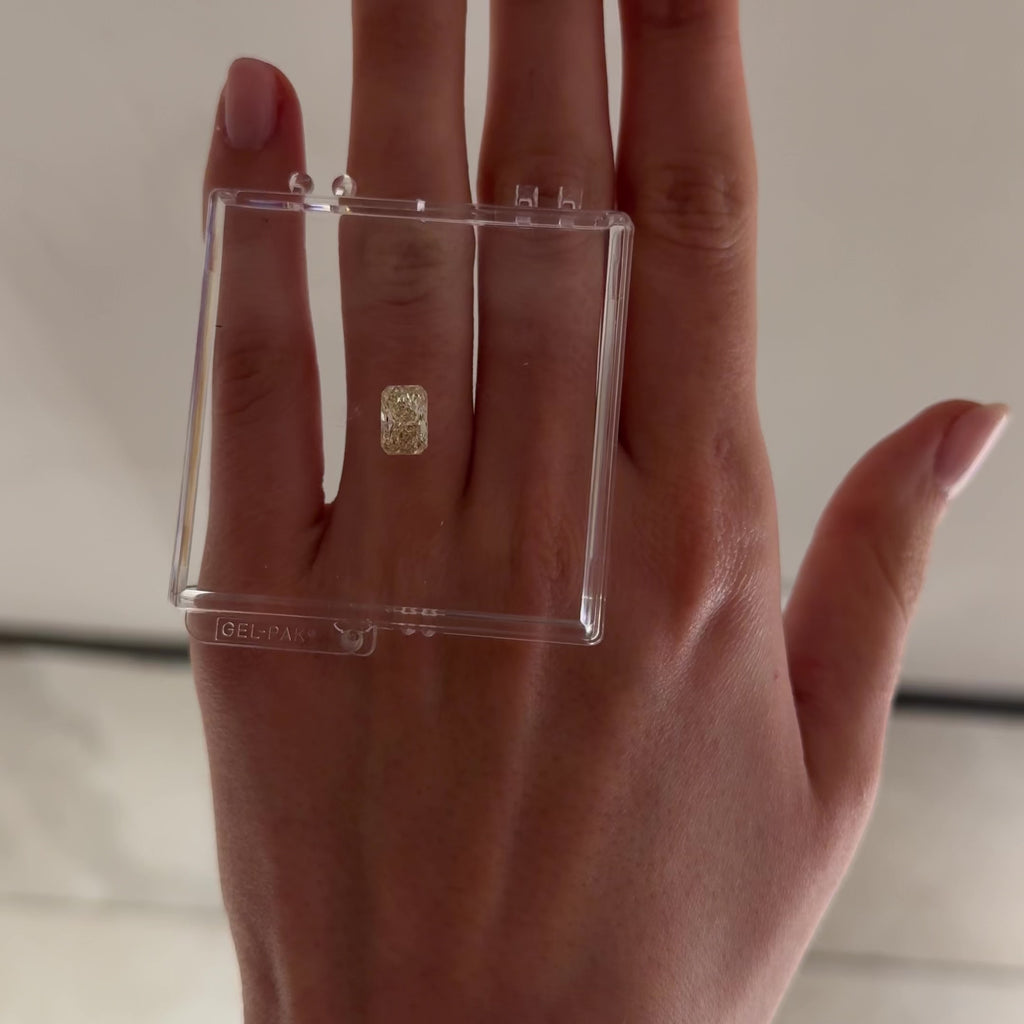loose yellow radiant cut diamond shown on a hand moving back and forth