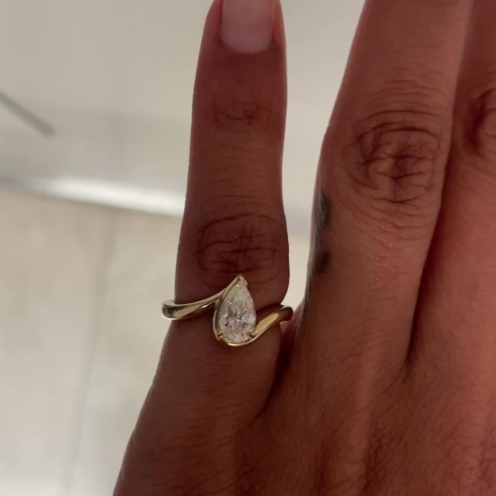 Video of hand model wearing BB Tala in 14k yellow gold on left hand pinky in front of a white wall.