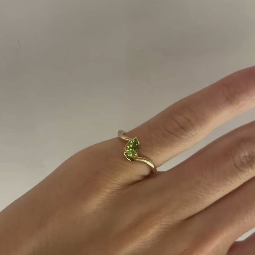 Hand model wearing BB Thelma Peridot in 14k yellow gold on left hand pinky in front of a white background.