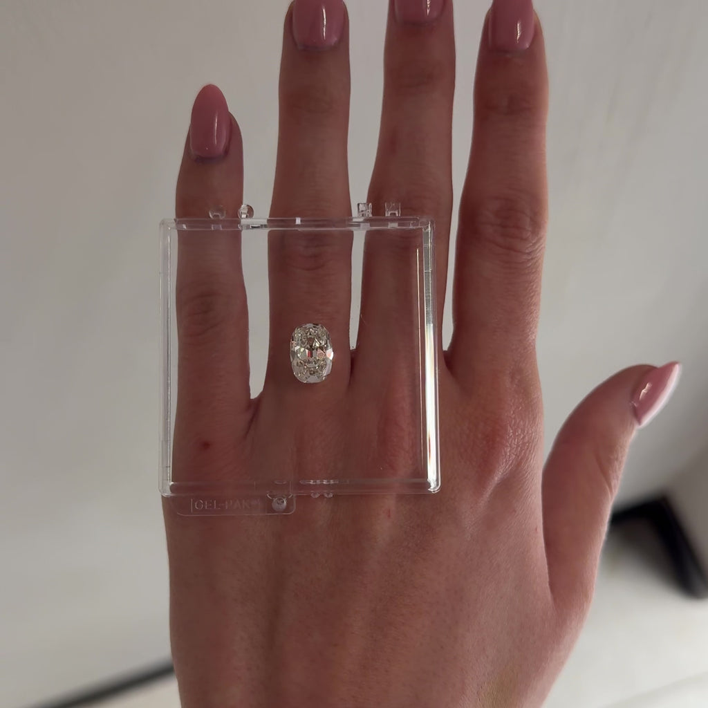 hand with loose diamond laid over ring finger tilting back and forth