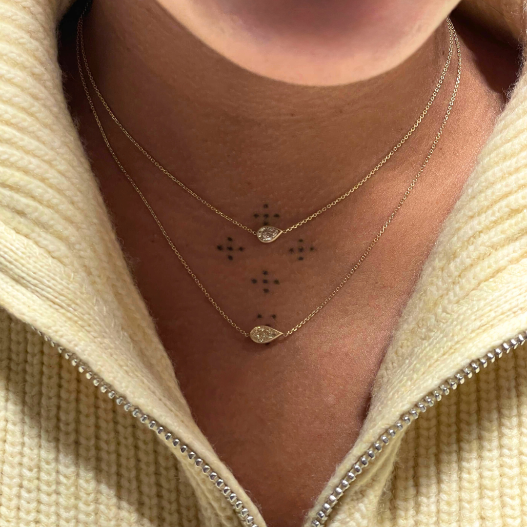 brown diamond max mini necklace and yellow diamond max necklace worn by woman in yellow sweater