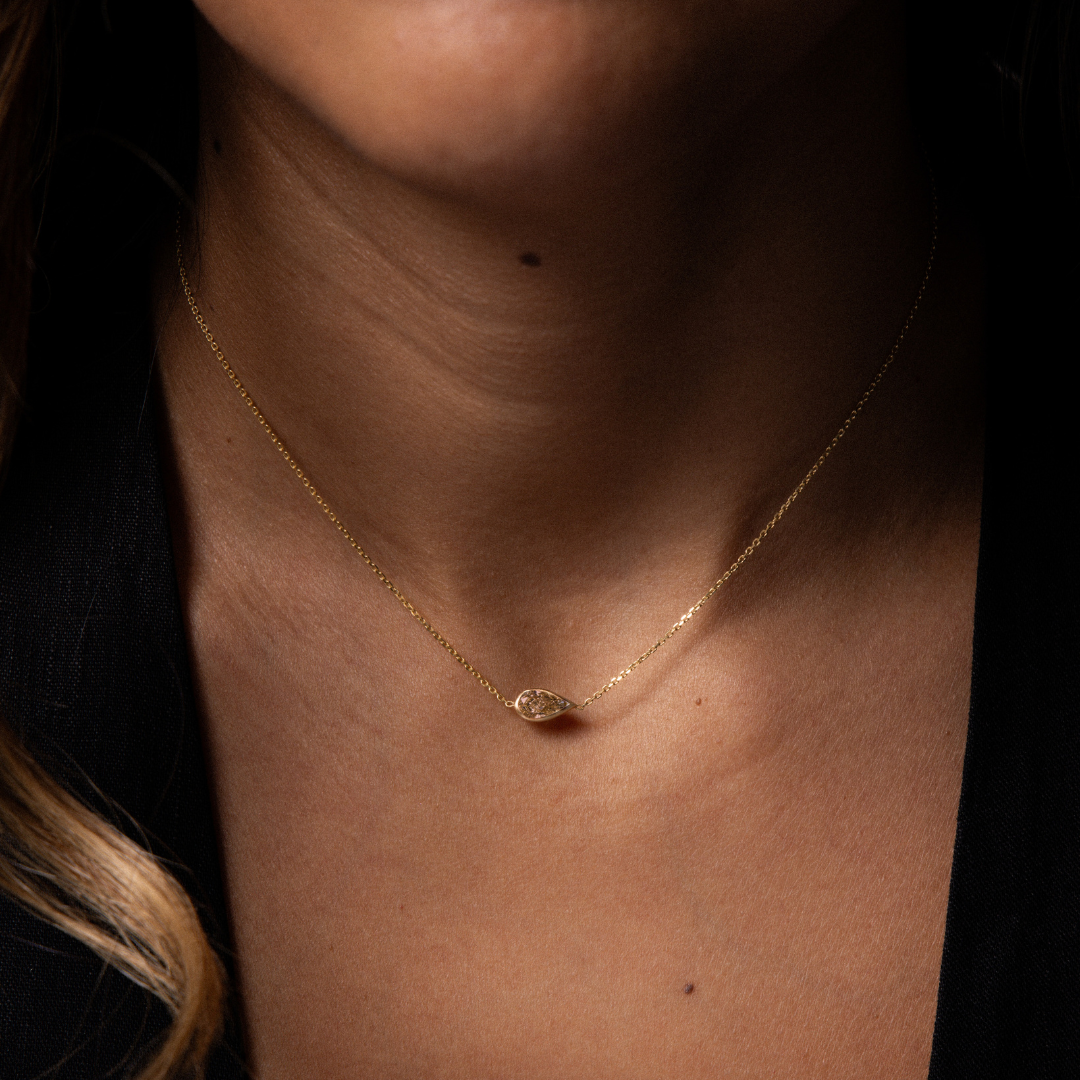 Brown pear cut diamond bezel set on a yellow gold necklace